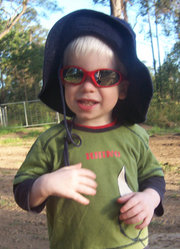 Child with OCA, enjoying the outdoors with sunglasses and hat